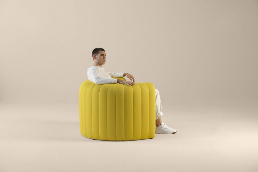 Hombre sentado en el sillón remanente amarillo mostaza de Sancal