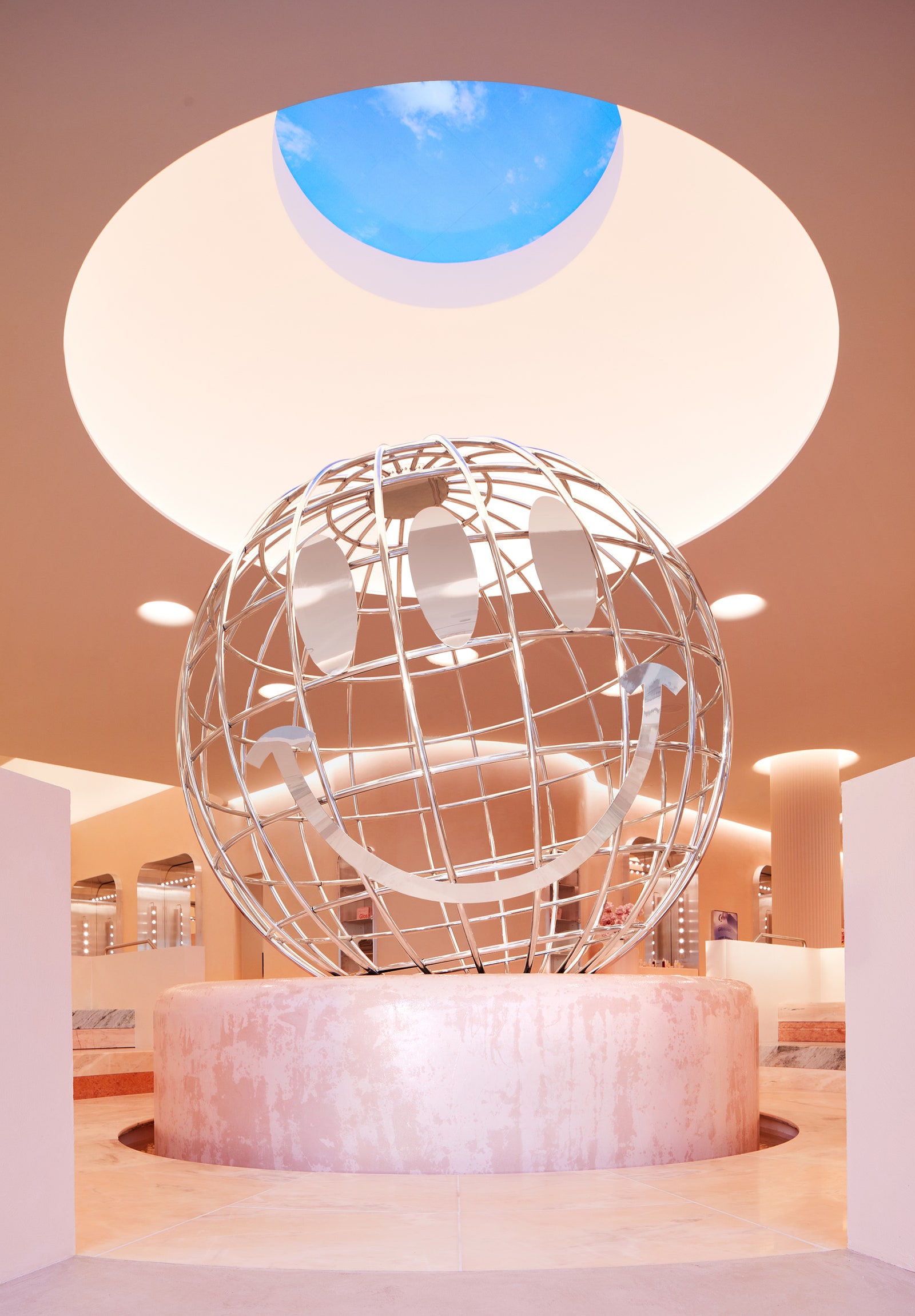 Una enorme escultura de acero llamada Glossier Globe corona la fuente en el centro de un fascinante lugar social, ...