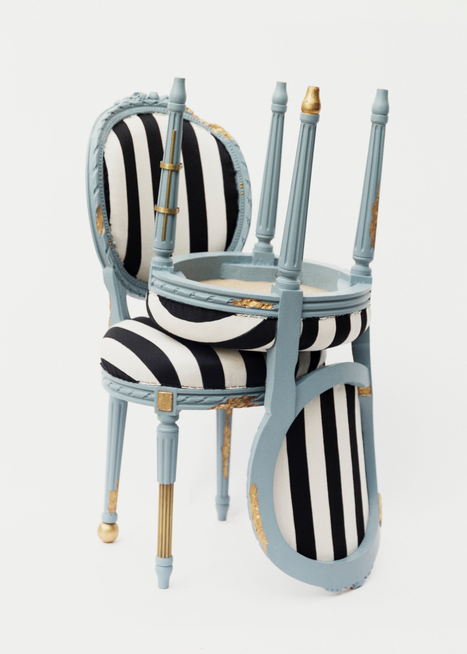 Dos sillas Dior Medallion con tapizado de rayas. Una silla cayó sobre la otra.